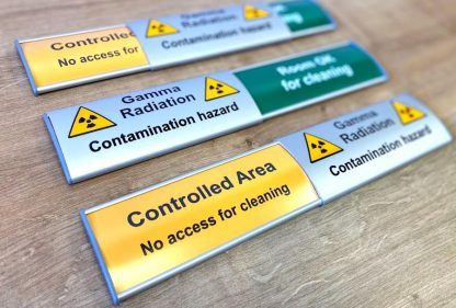 aluminium-sliding-door sign-with-text-reading gamma-radiation-contamination-hazard controlled-area-sliding